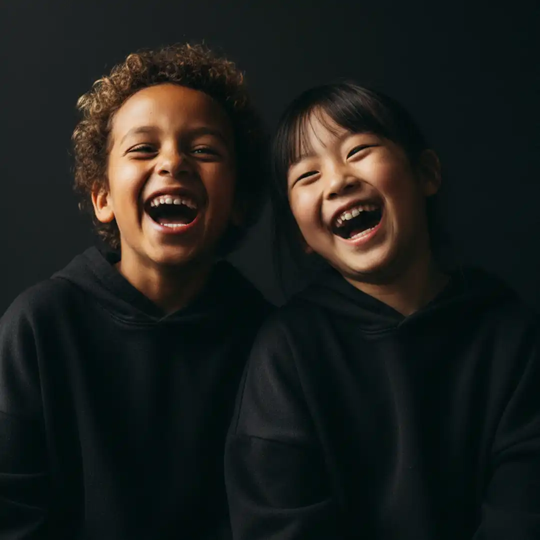 Kinderlachen, ein Kind stützt sich auf die Ellenbogen und lacht freudig in die kamera