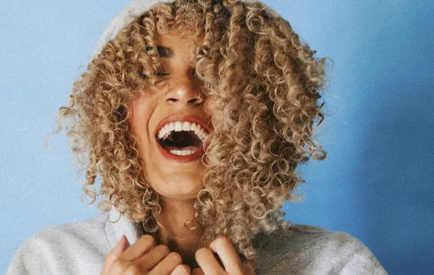 Schwarze Frau mit Hoodie, laut lachend